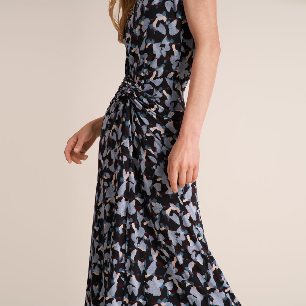 Woman wearing a patterned navy and light blue printed sleeveless midi dress