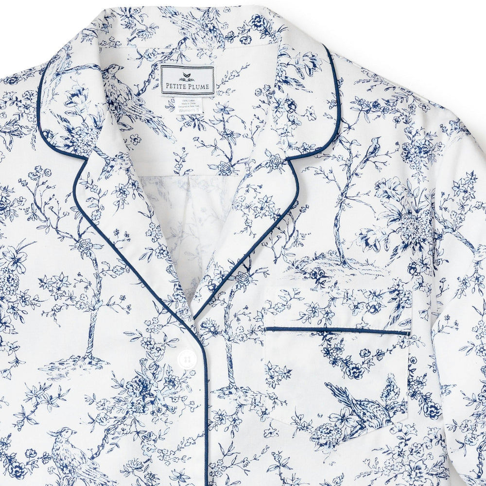White pajama top with blue floral pattern and piping on a white background