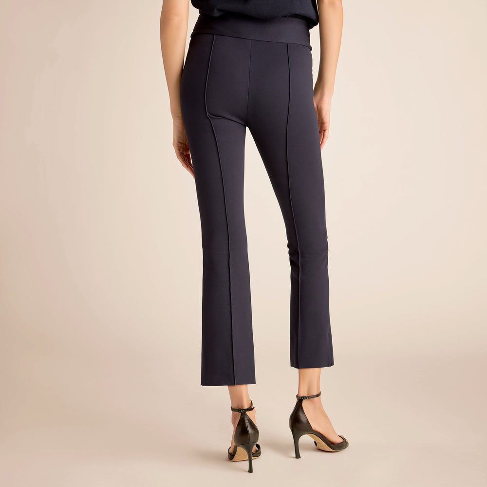 Navy blue pants worn by a person on a beige background