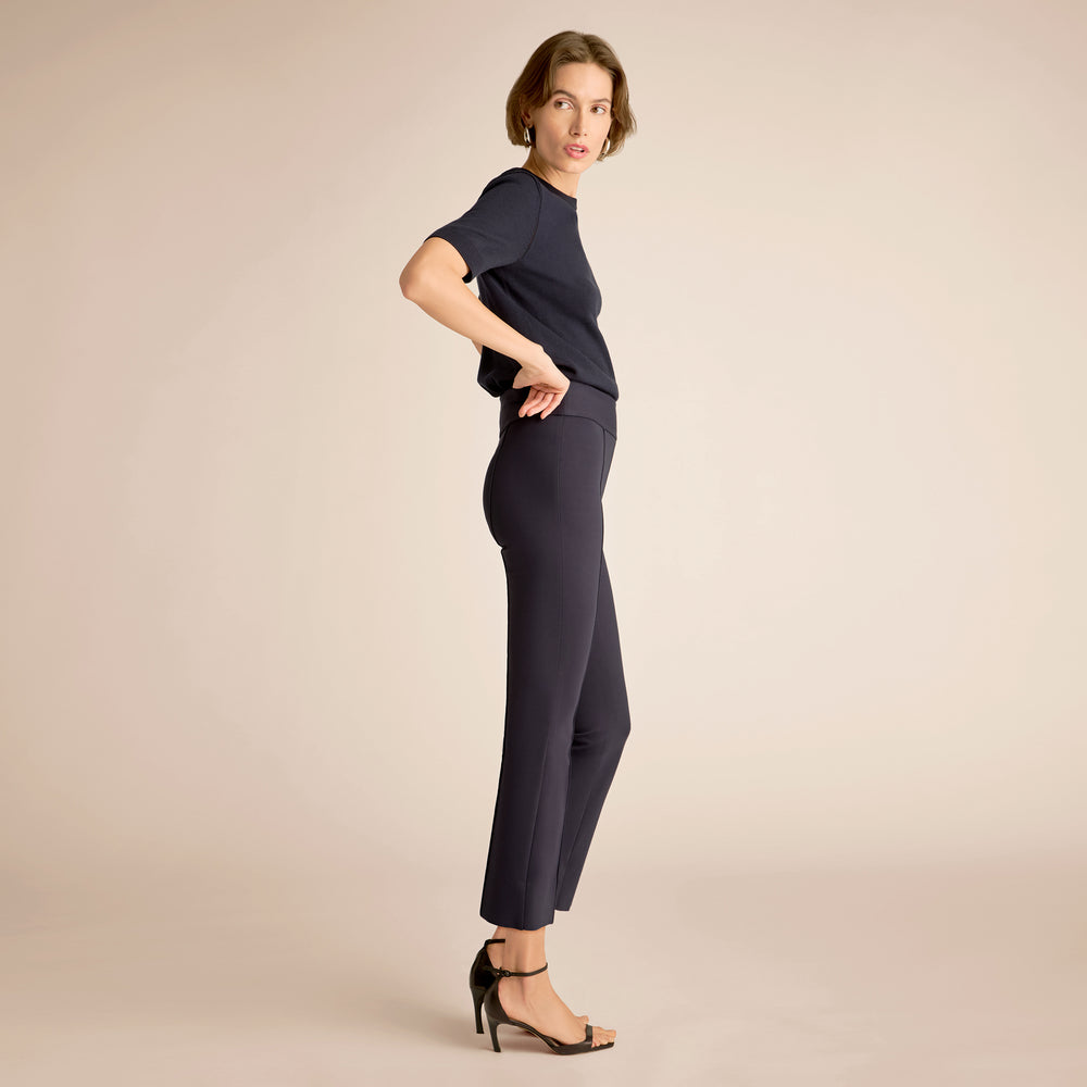 Woman wearing a navy outfit on a beige background