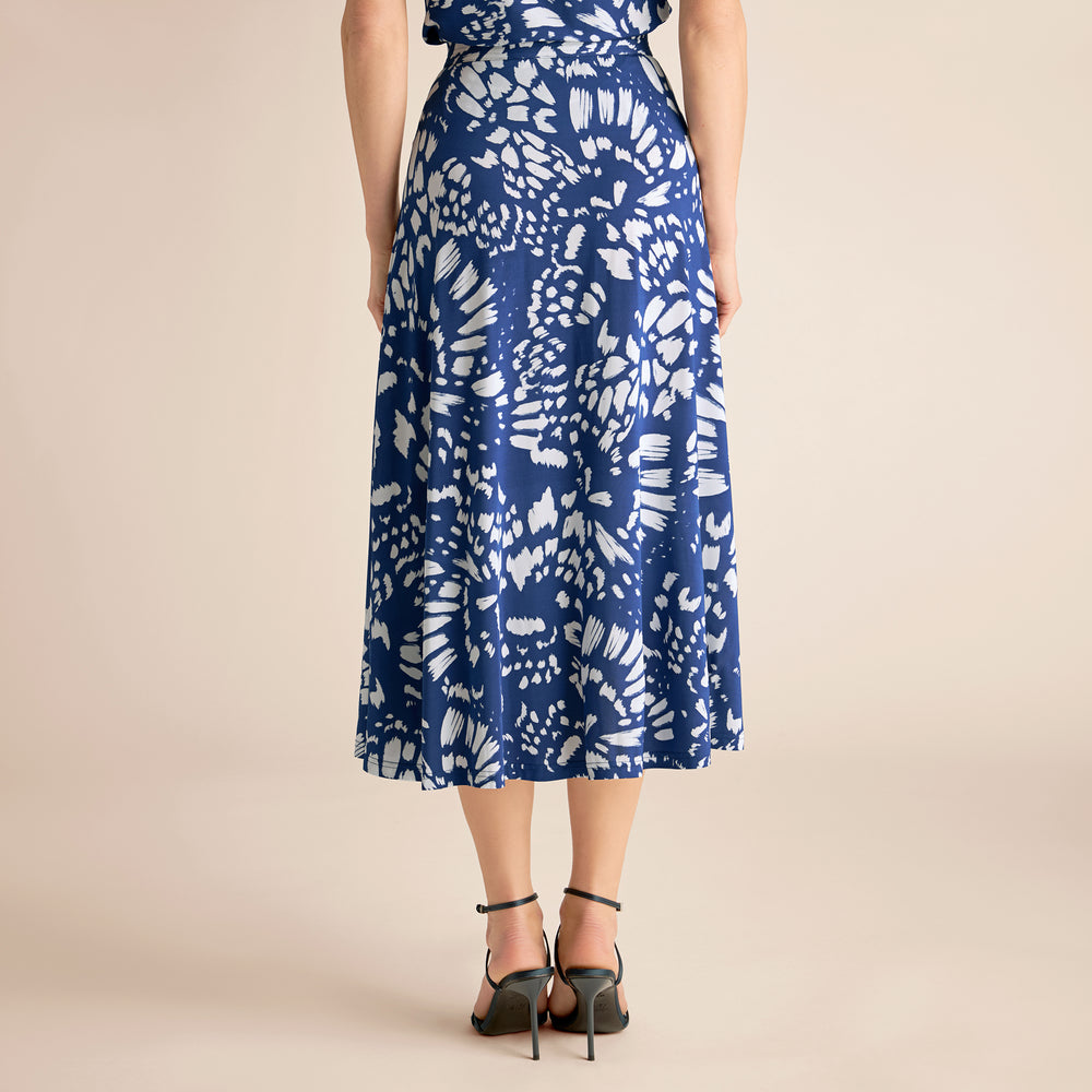 Woman wearing a blue and white patterned dress on a beige background