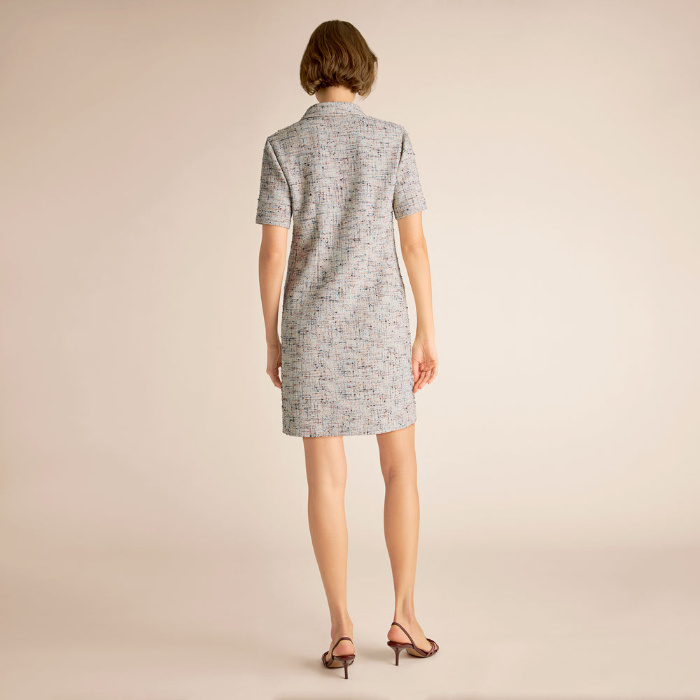Woman wearing a gray dress on a beige background