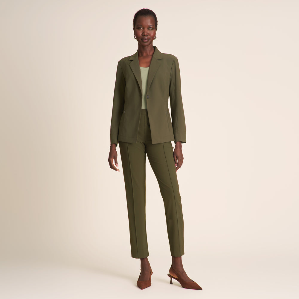 Woman wearing an olive green suit on a beige background