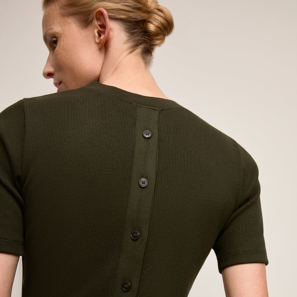 Green ribbed sweater with buttons on a plain background