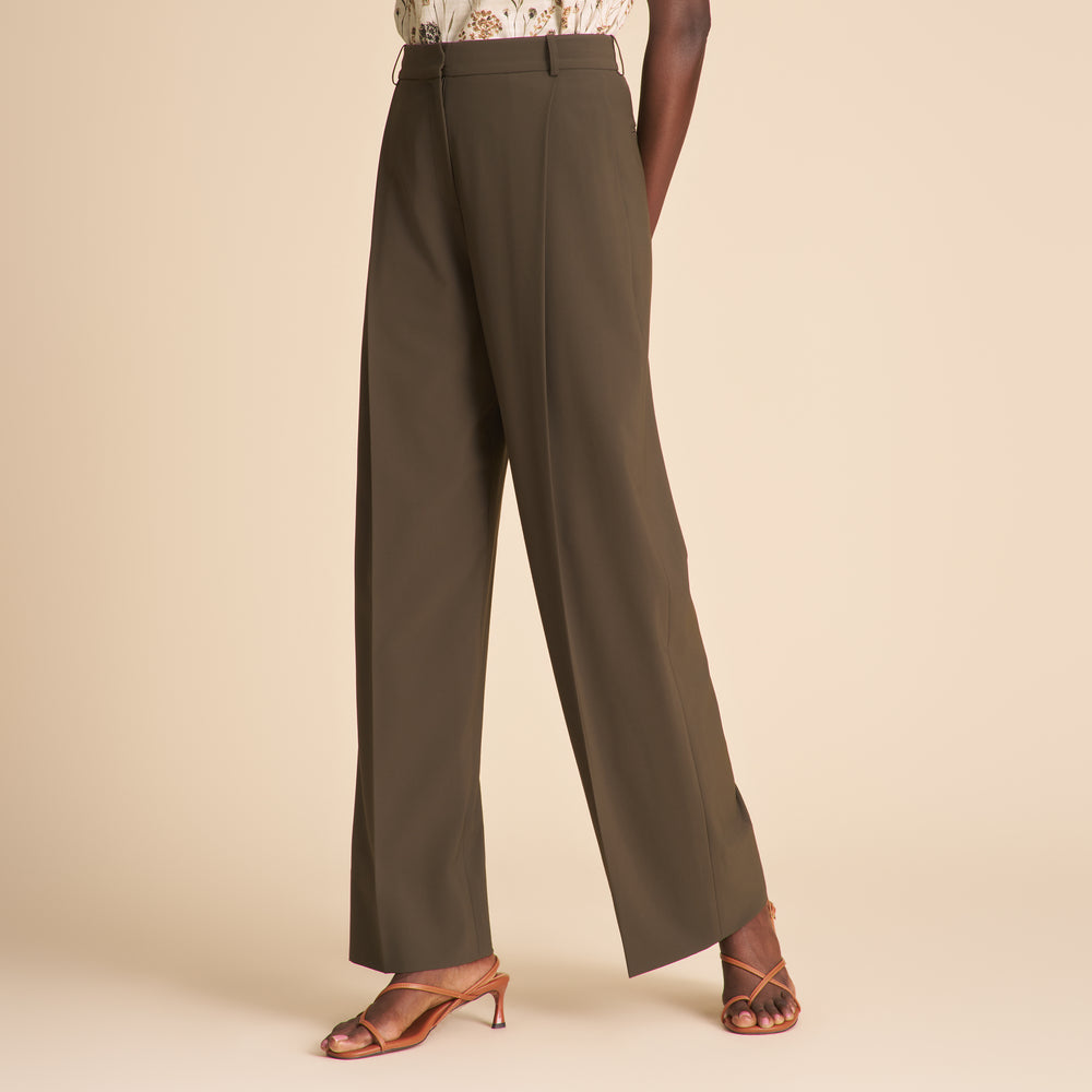 Brown wide-leg pants worn by a person on a beige background
