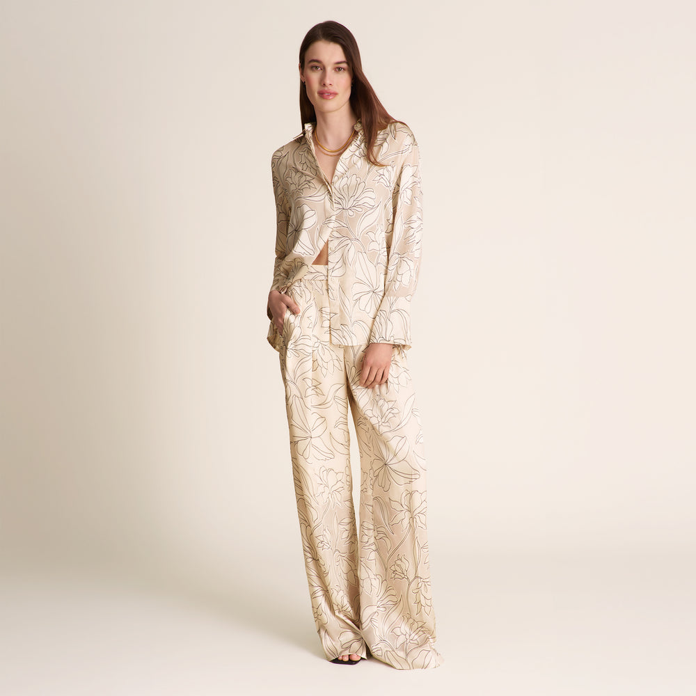 Woman wearing a gold and white patterned suit on a beige background