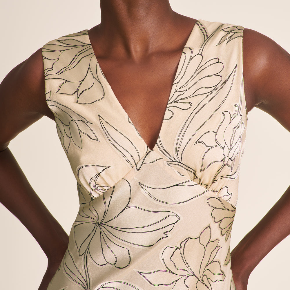 Beige sleeveless dress with floral pattern on a neutral background