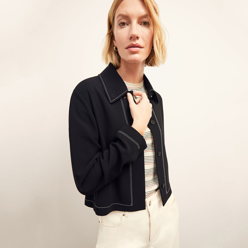 front image of a woman wearing the nicky jacket in black