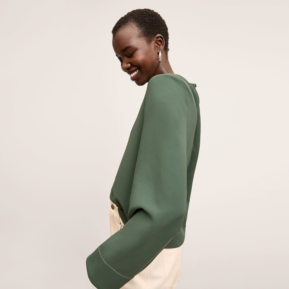 side image of a woman wearing the jules top in dusty pine