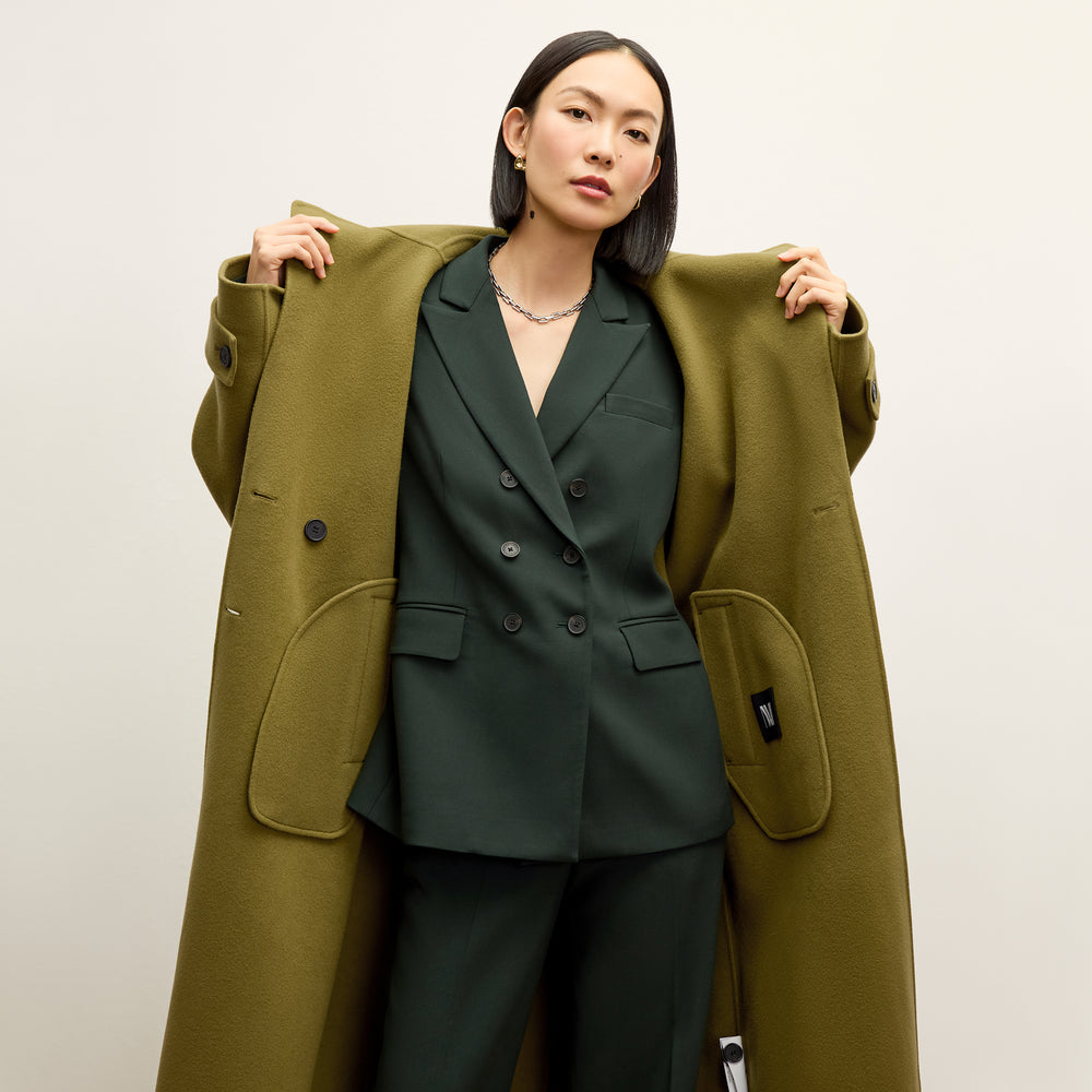 front image of a woman wearing the viola coat in pistachio