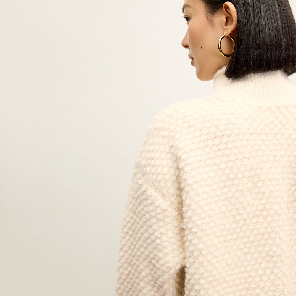 back image of a woman wearing the lea sweater in snow