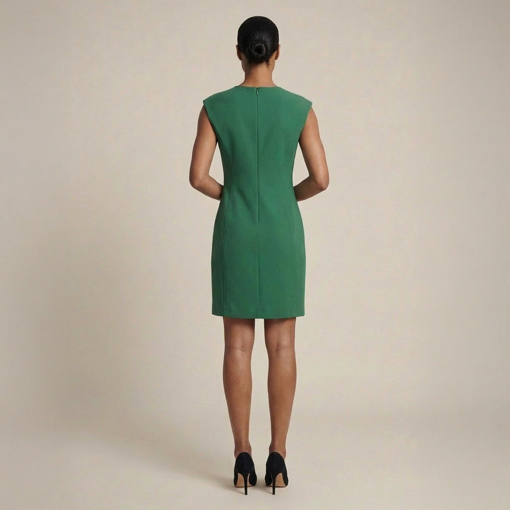 Green dress worn by a model on a beige background