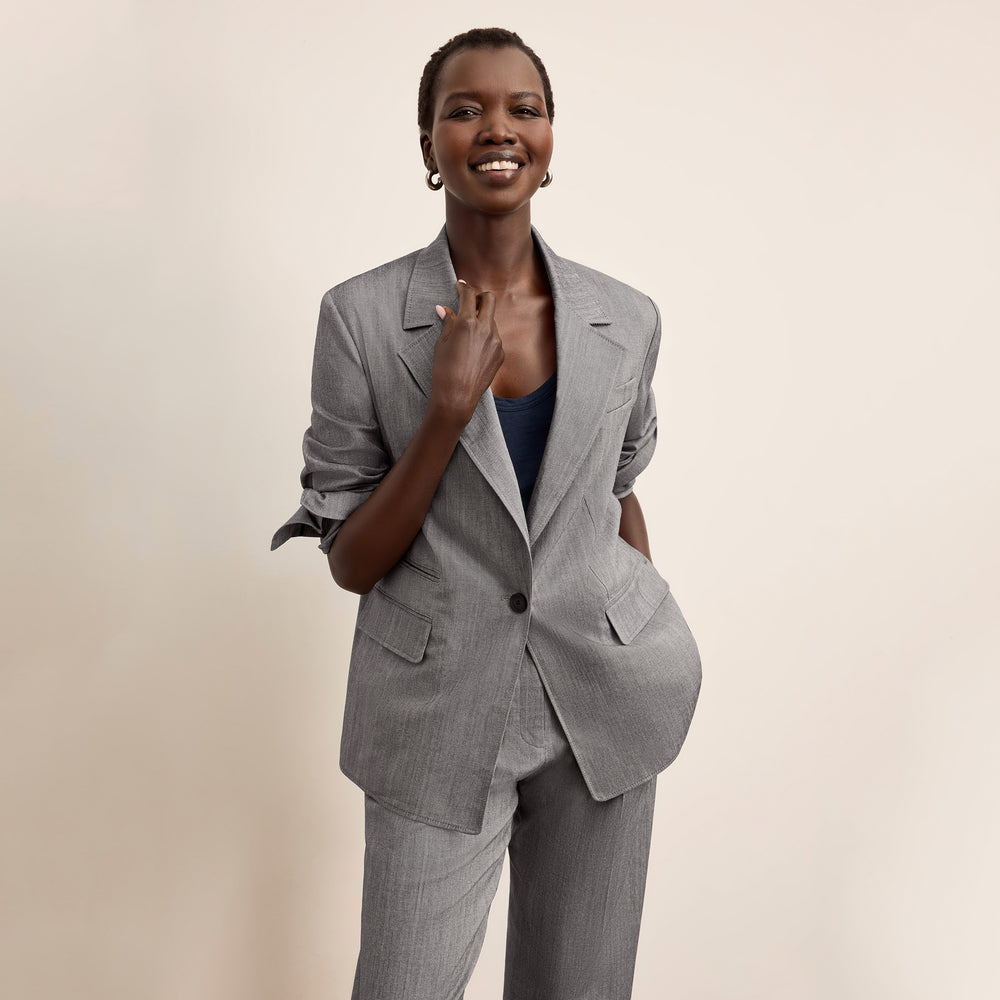 Woman wearing a gray suit on a beige background