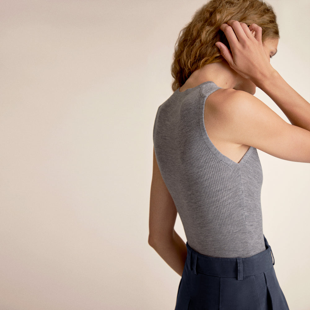 Woman wearing a gray tank top and a blue skirt