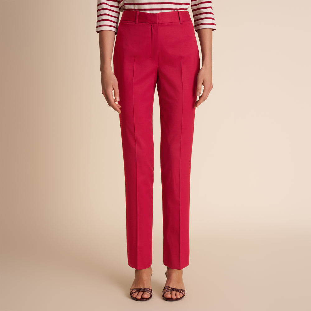 Red pants worn by a person on a beige background