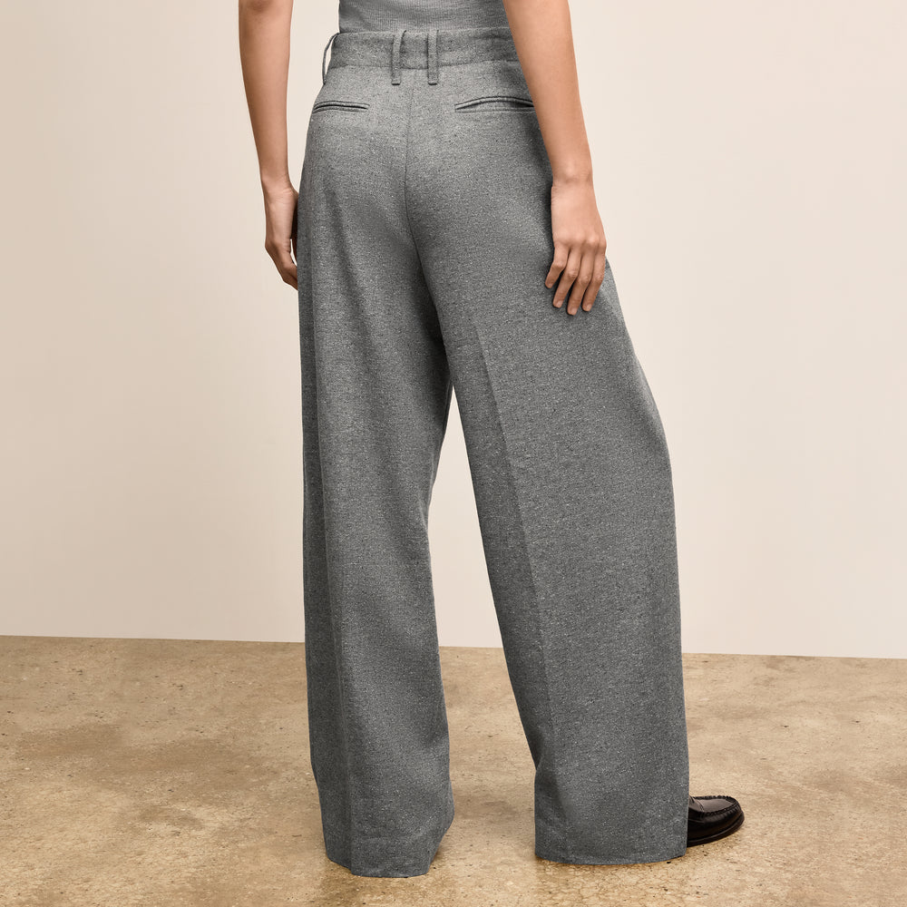 Person wearing gray wide-leg pants on a beige background