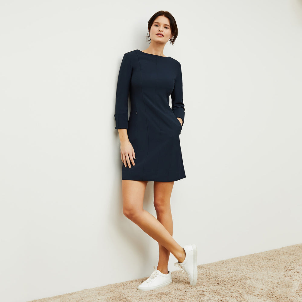 Front image of a woman standing wearing the Novara Dress—Recycled WonderTex in Midnight