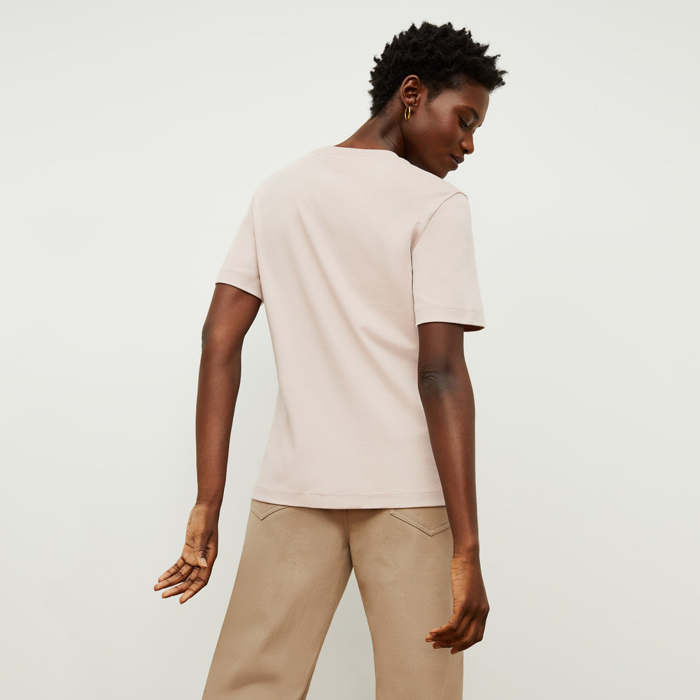 Back image of a woman standing wearing the Leslie T-Shirt—Compact Cotton in Dusty Pink