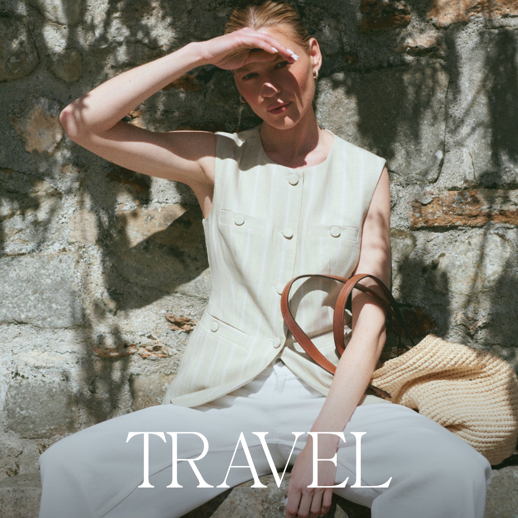 Woman sitting against a stone wall with a handbag, wearing a sleeveless top and pants, with 'TRAVEL' text overlay.