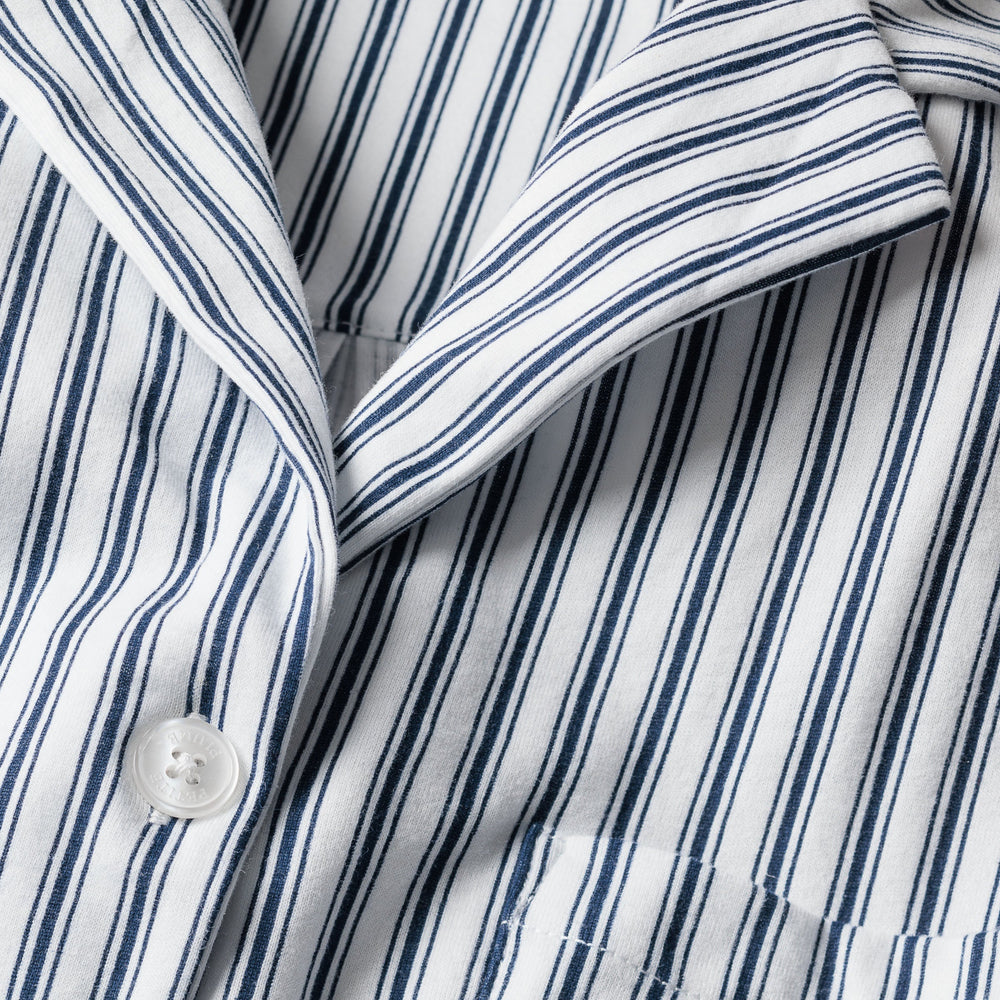 Close-up of a blue and white striped shirt with a button.
