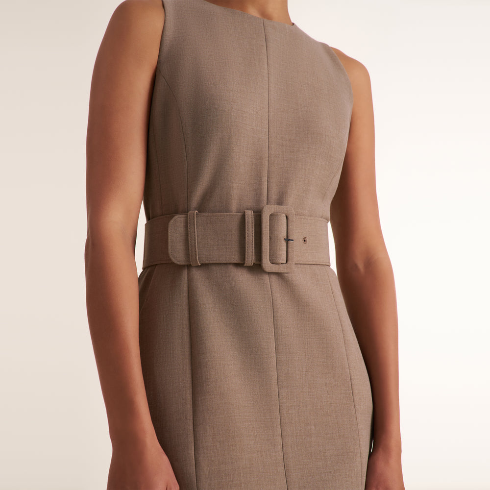 A sleeveless taupe-brown dress with a matching belt and square buckle, shown on a model against a plain light background.