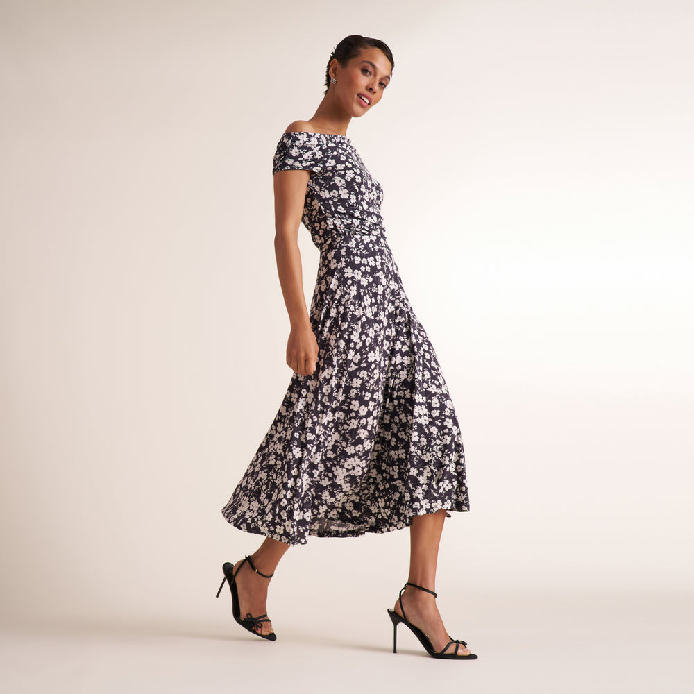 Woman wearing a floral off the shoulder top and matching skirt to make it look like a dress