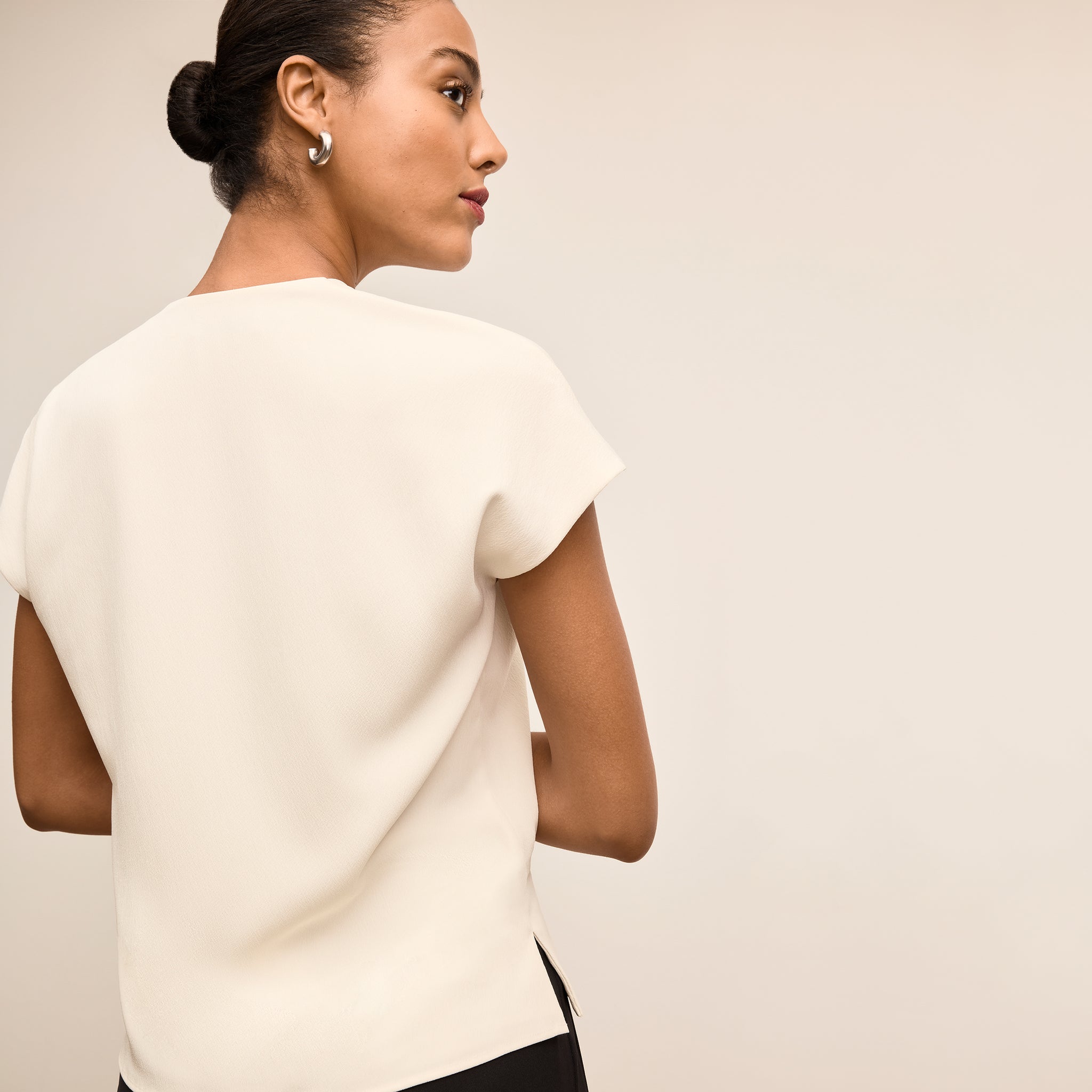 Woman wearing a white blouse against a plain background