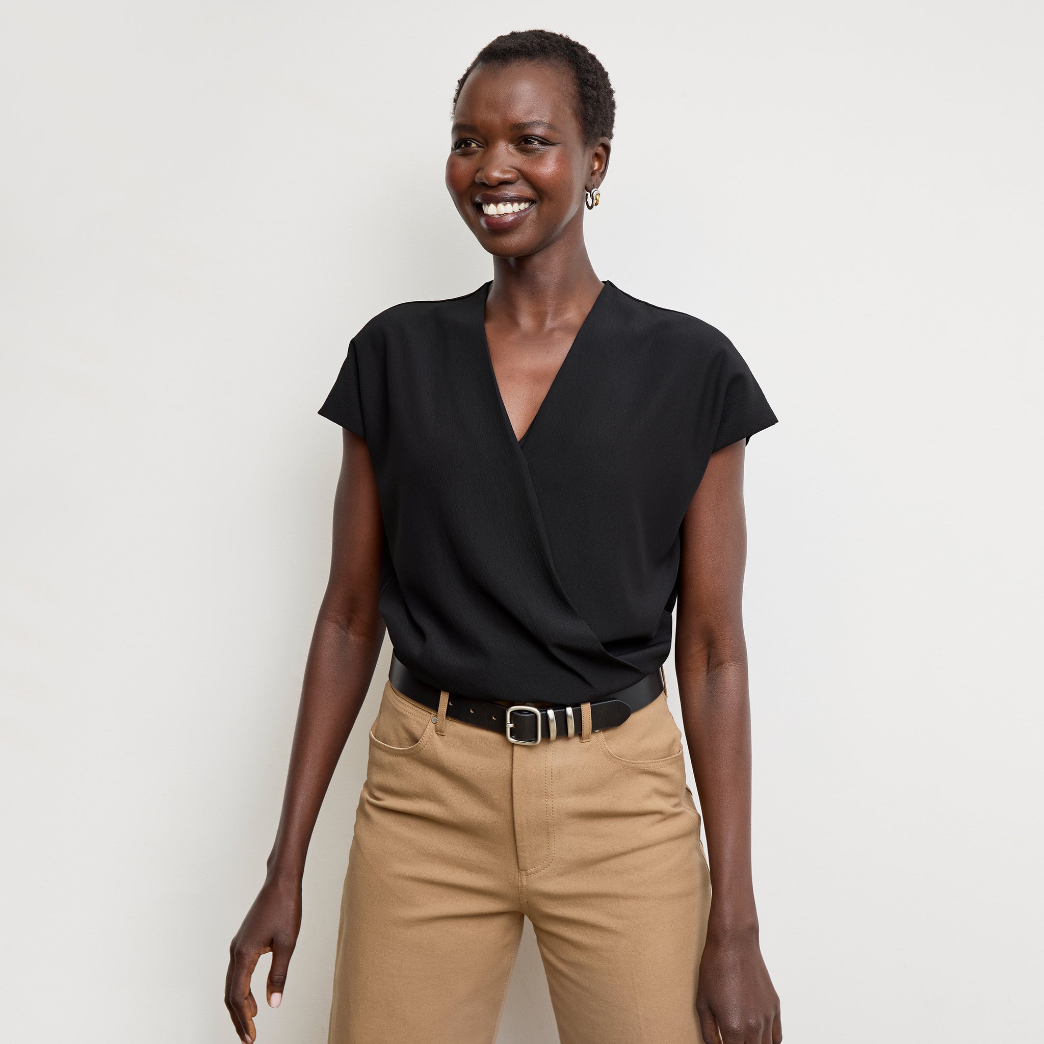 Front image of a woman standing wearing the antonia top soft wave in black 