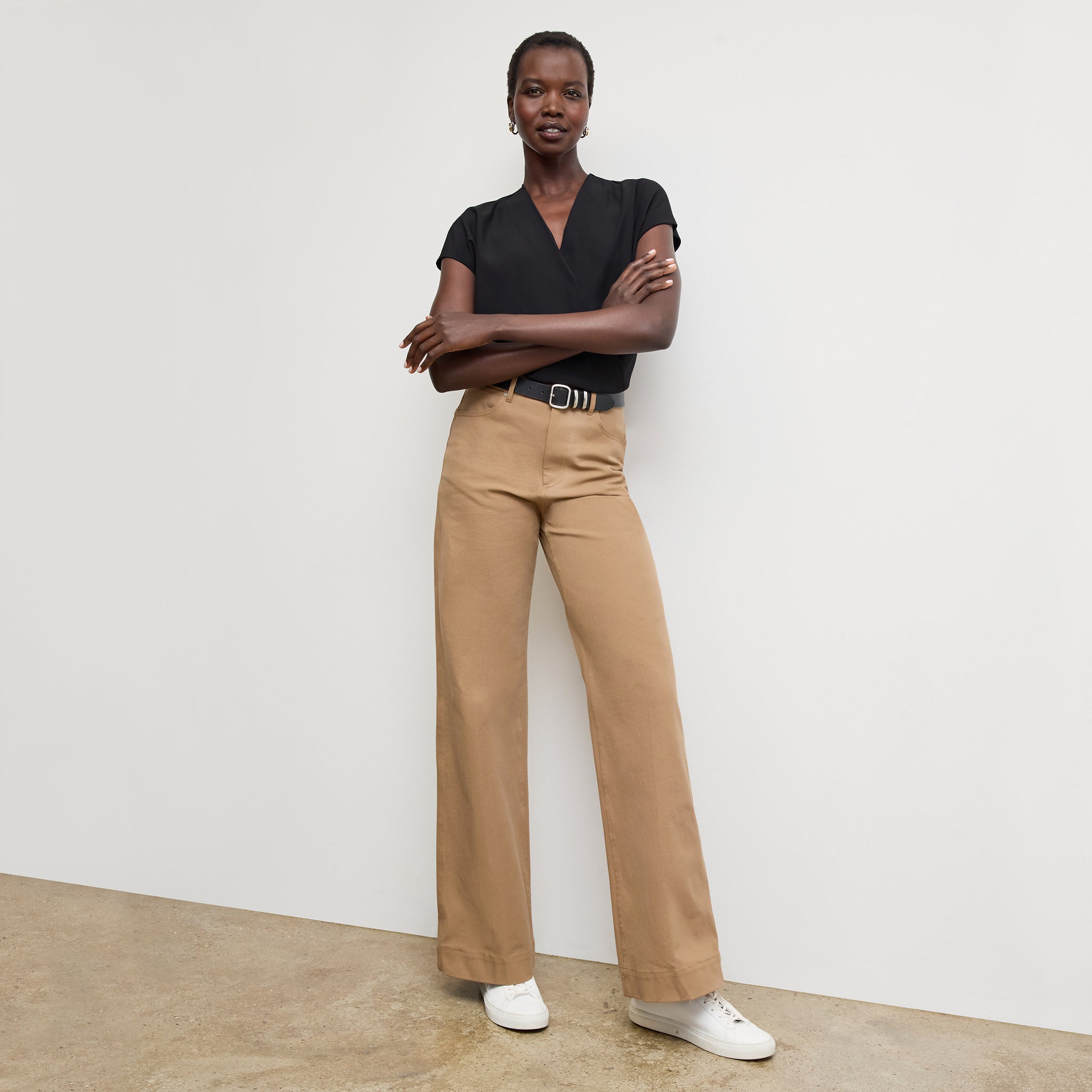 Front image of a woman standing wearing the antonia top soft wave in black