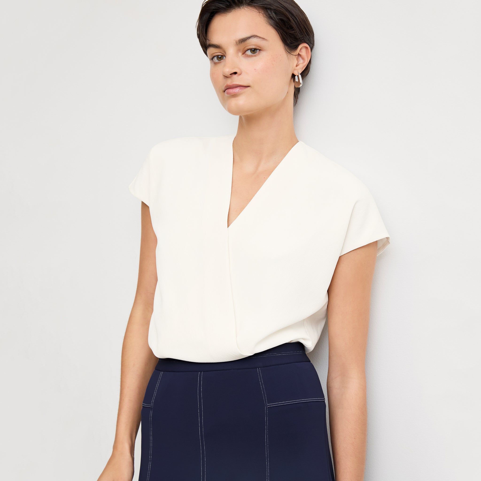 Front image of a woman standing wearing the Antonia Top—Soft Wave in Alabaster 