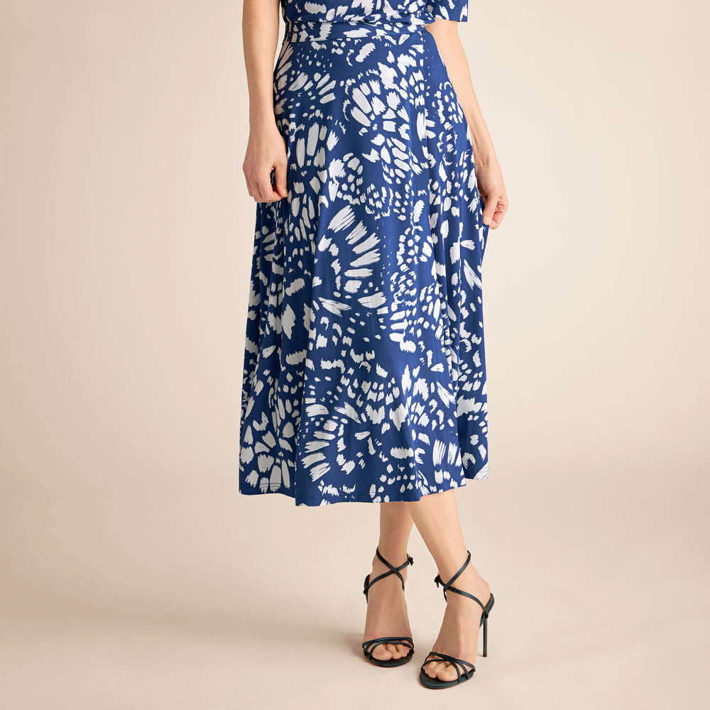 Woman wearing a blue and white patterned dress on a beige background