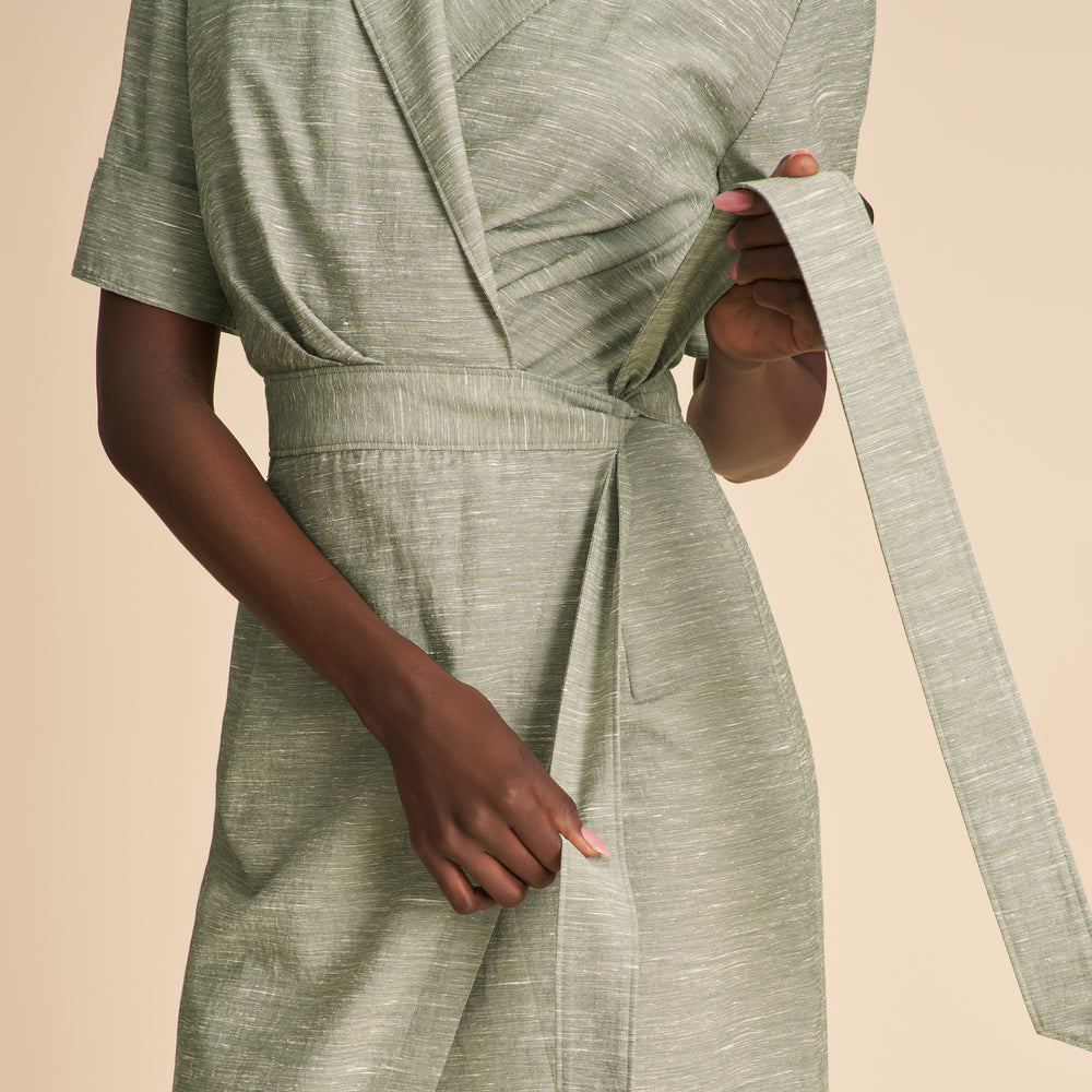 Green dress with a belt on a beige background