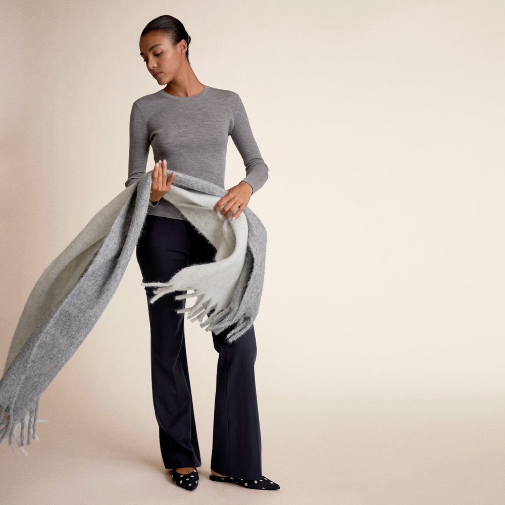 Woman wearing gray long sleeve holding a scarf