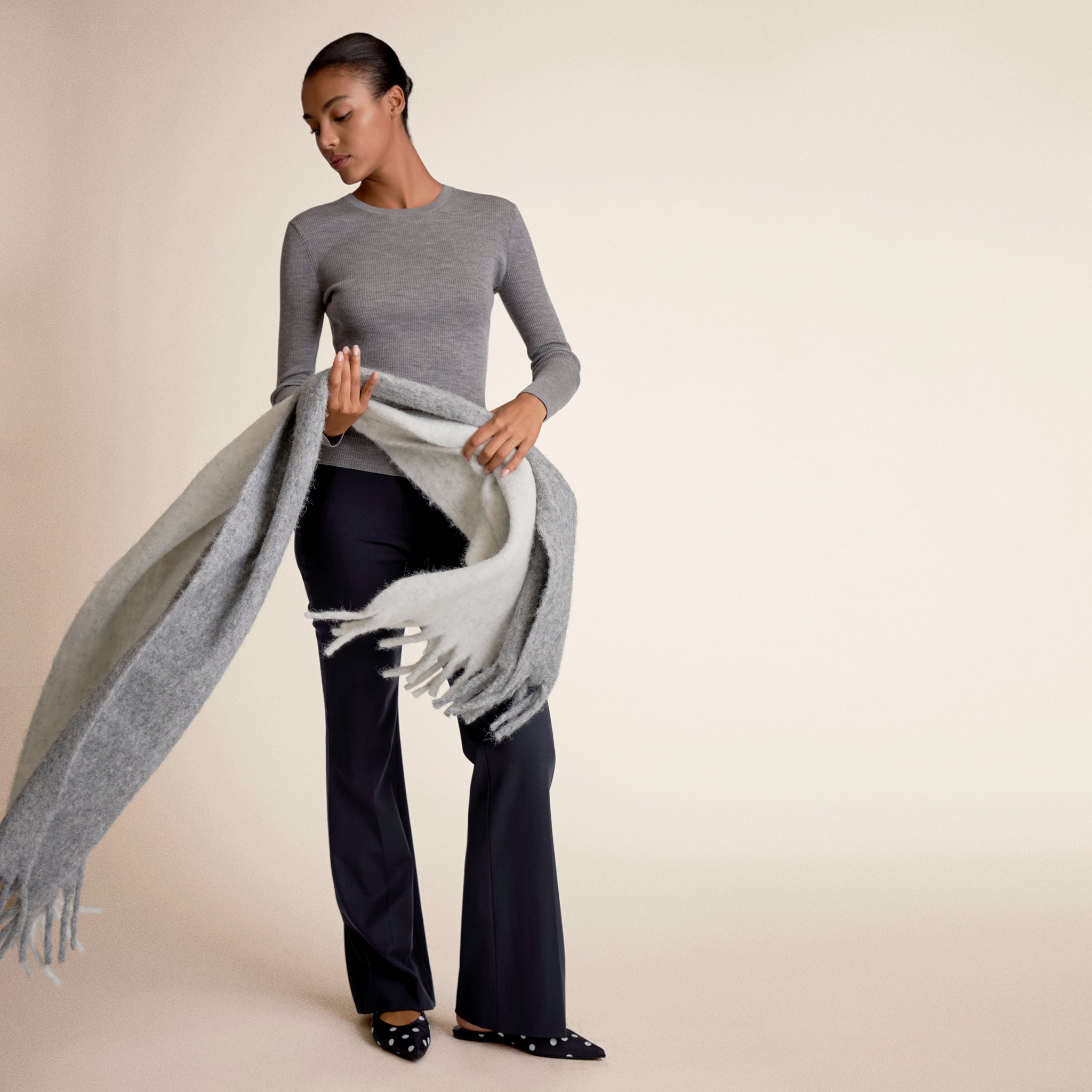 Woman wearing gray long sleeve holding a scarf 