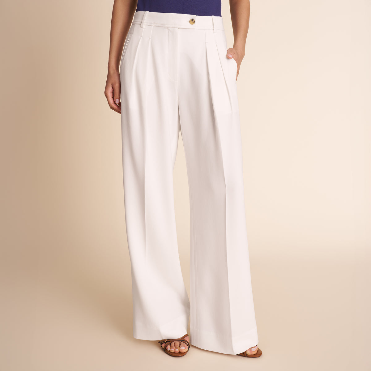 White wide-leg pants worn by a person on a beige background