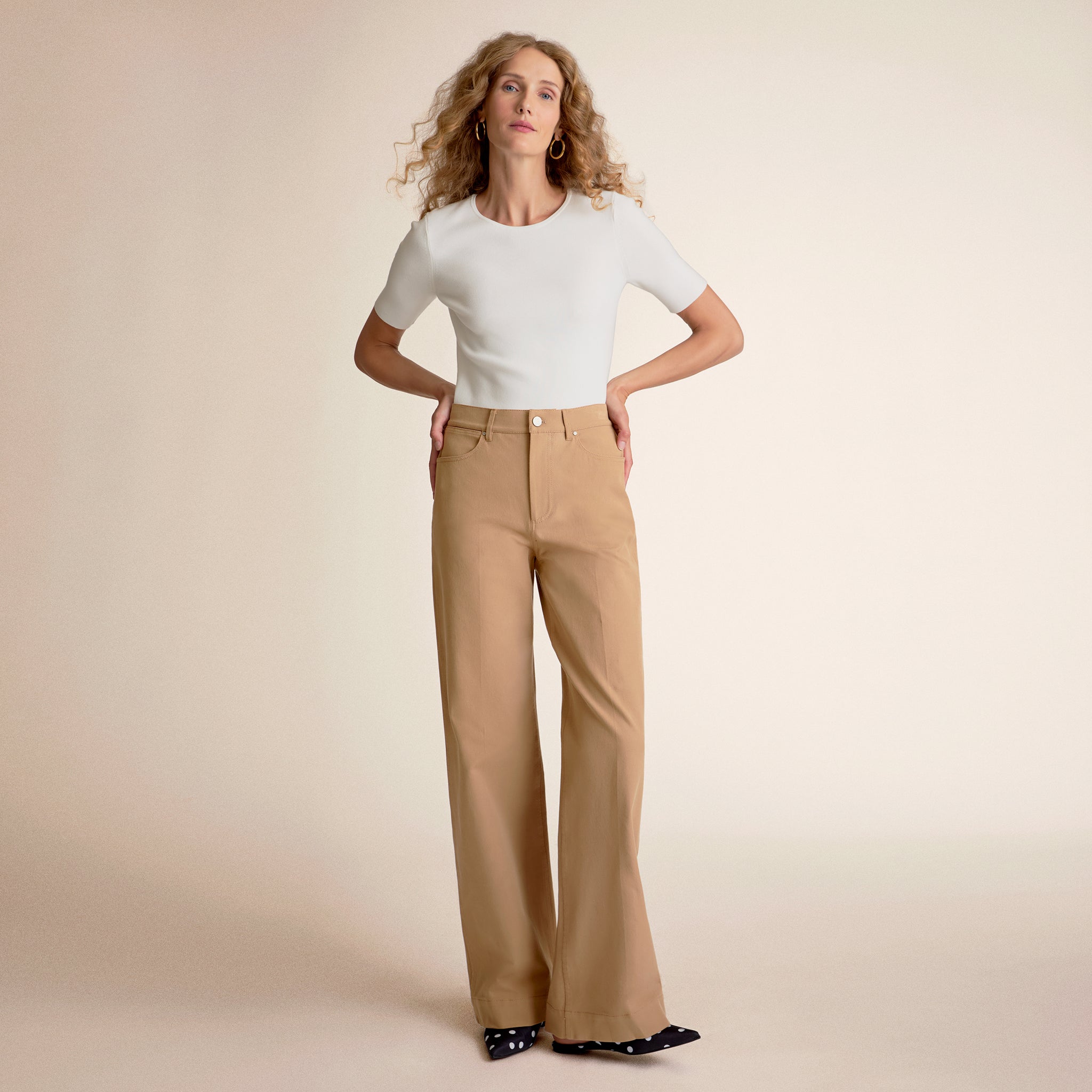 Front image of a woman standing wearing the choe top in ivory 