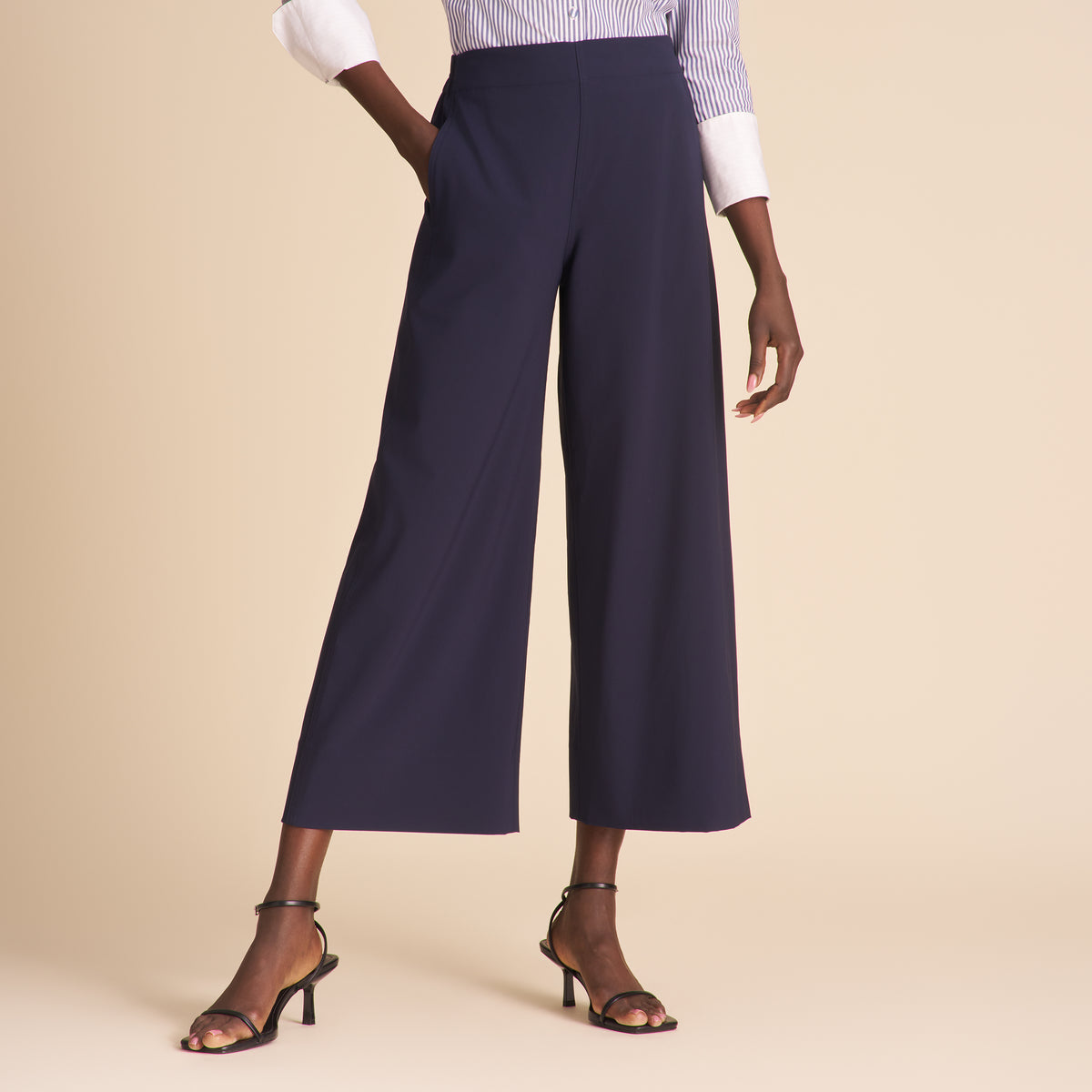 Navy wide-leg pants worn by a person on a beige background