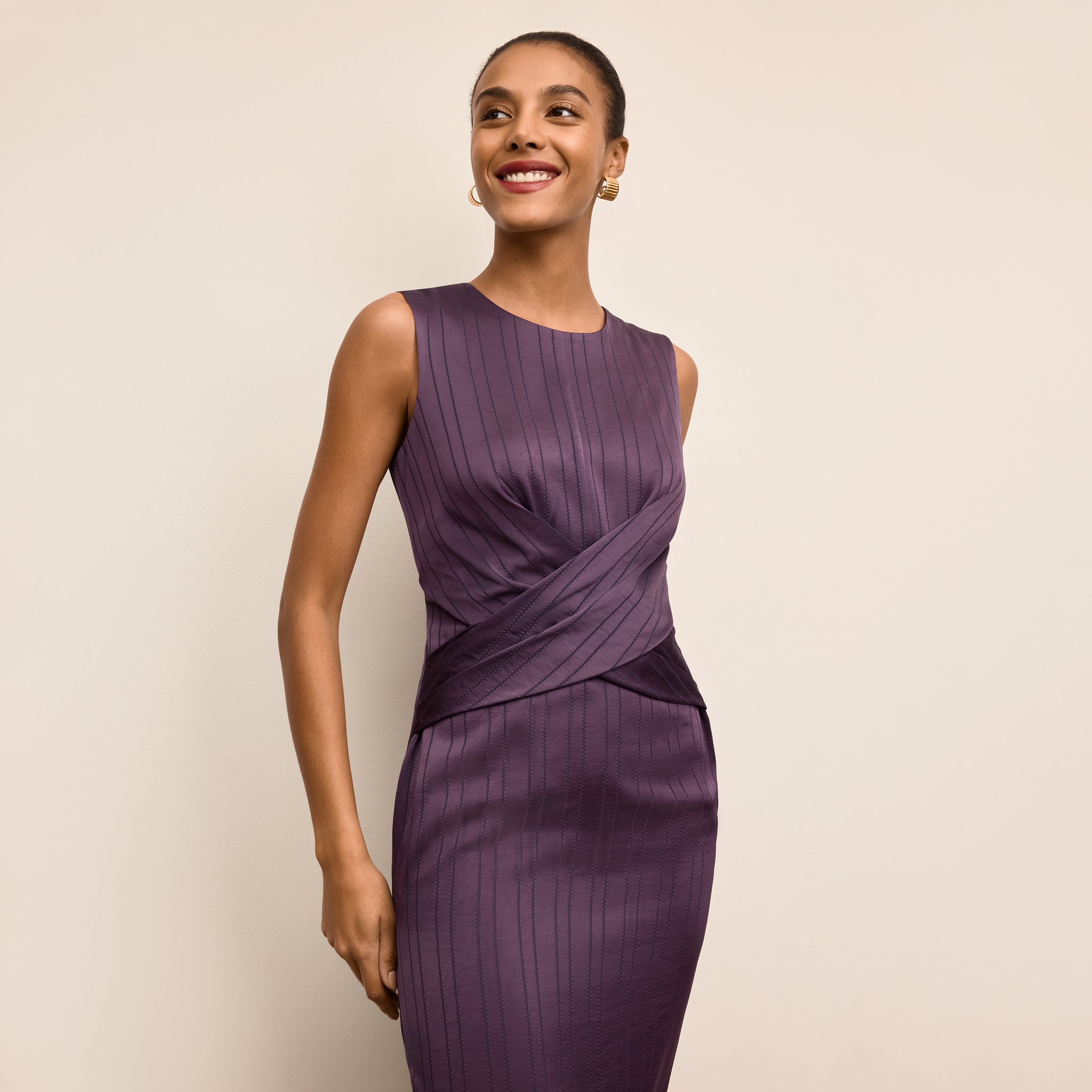 Woman wearing a purple dress against a beige background