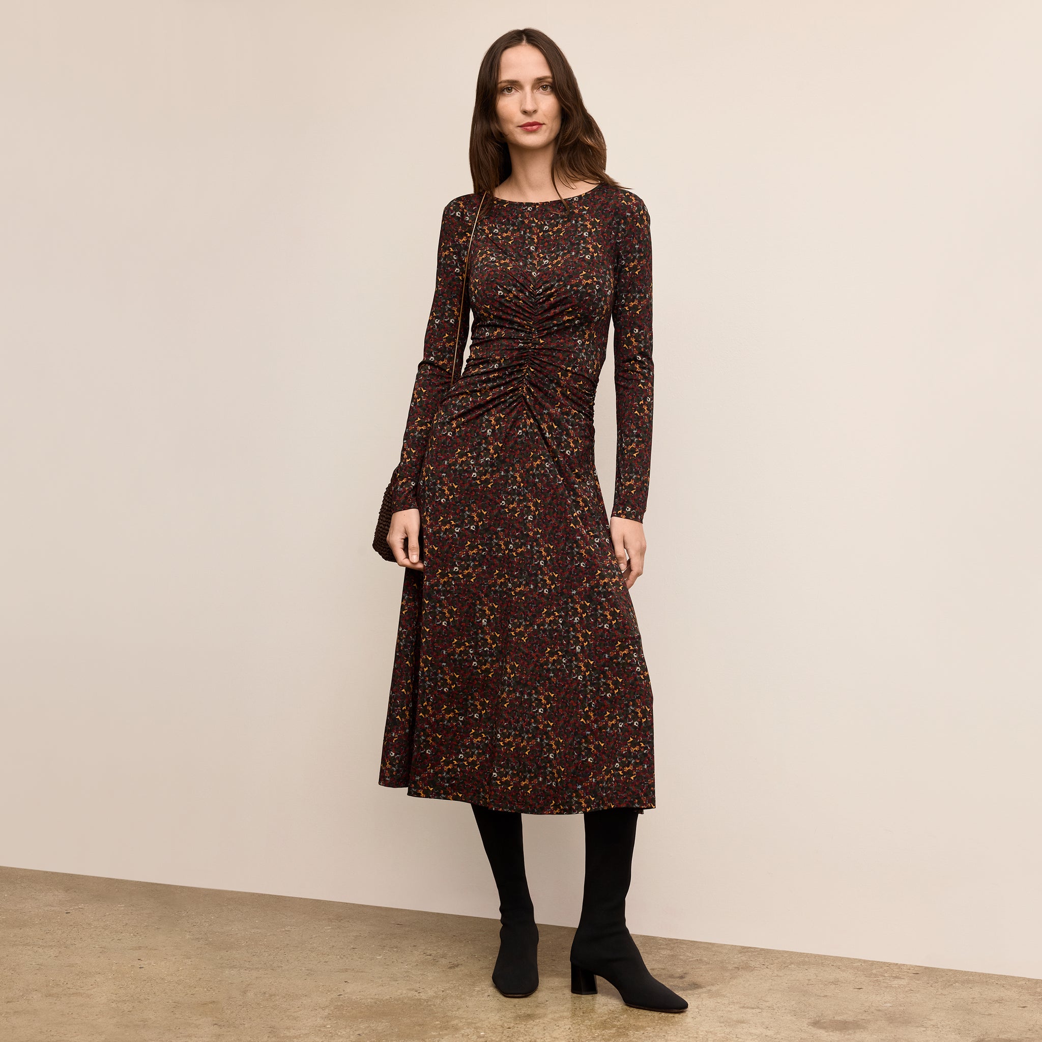 Woman wearing a patterned dress against a plain background 