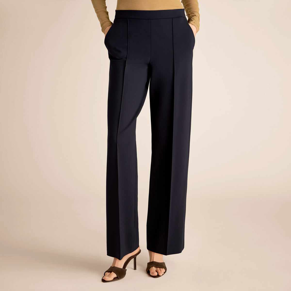 Navy blue pants worn by a person on a beige background