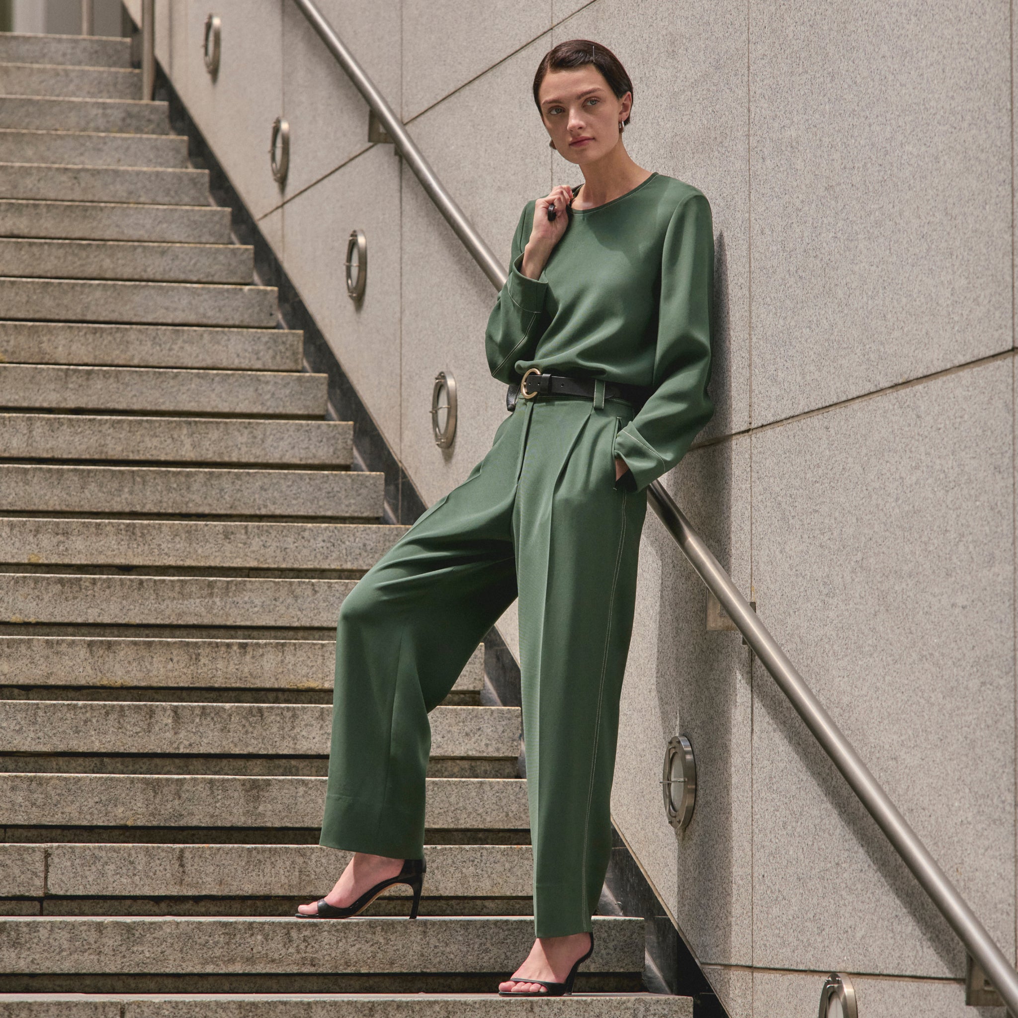 front image of a woman wearing the arlo pants in dusty pine