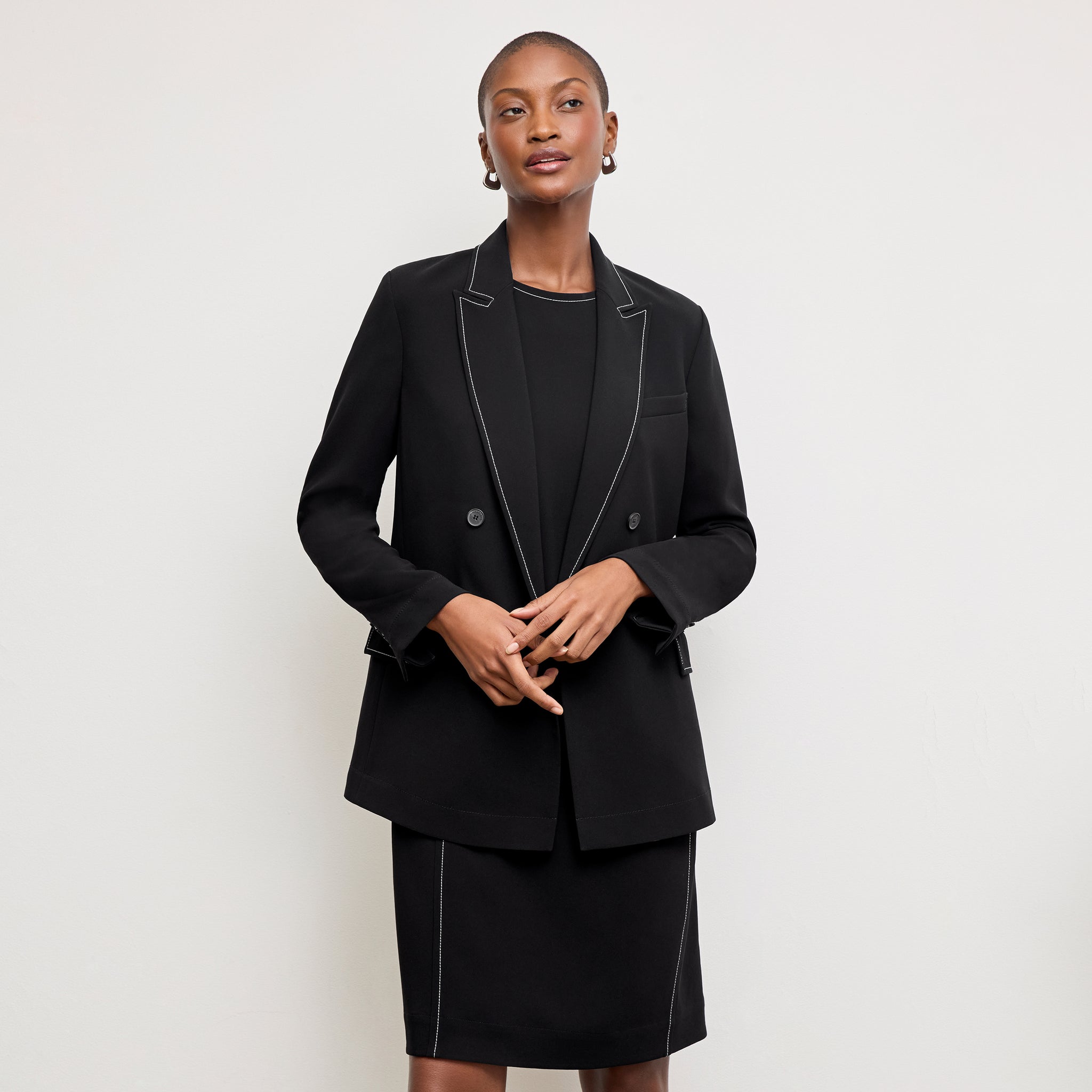 front image of a woman wearing the lancia dress in black with topstitch
