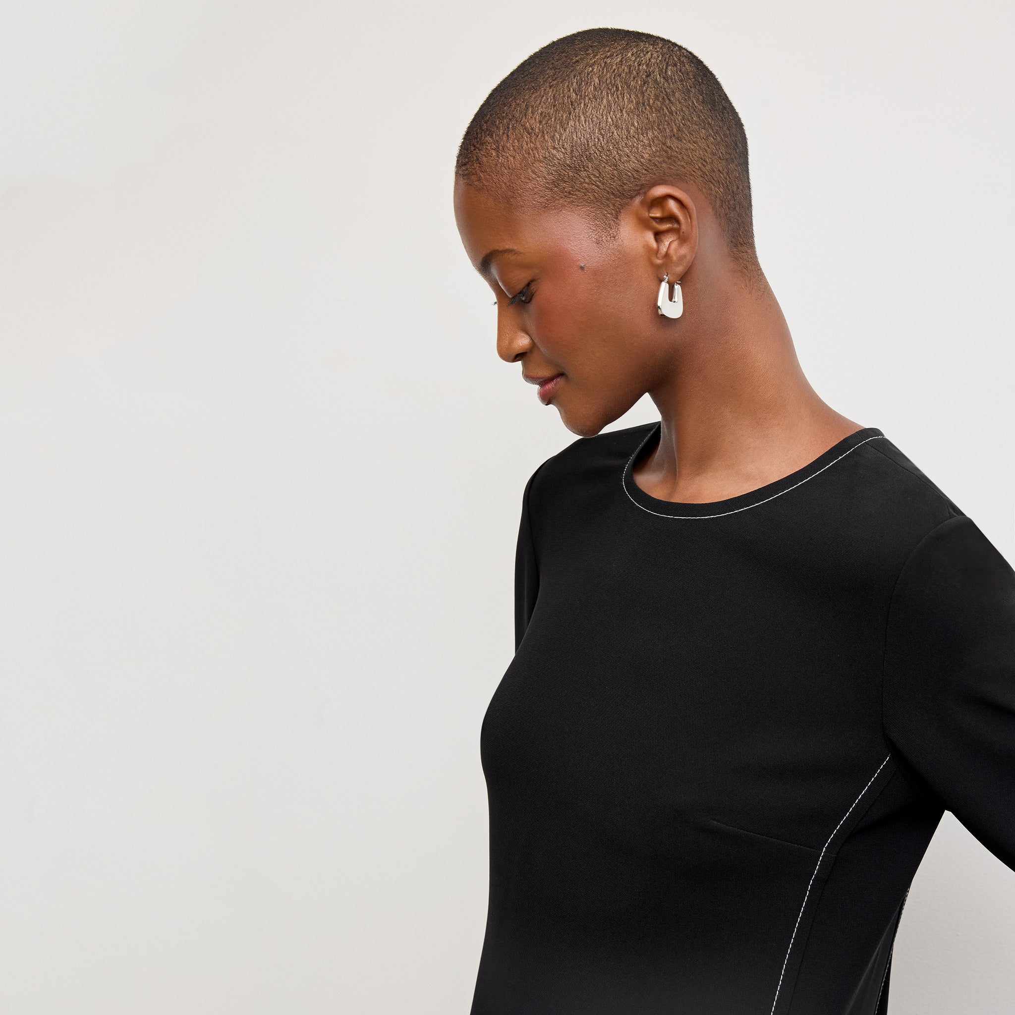 front image of a woman wearing the lancia dress in black with topstitch