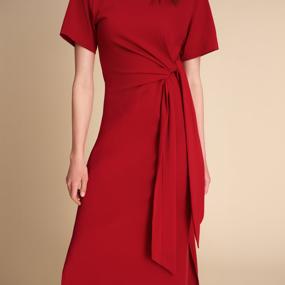 Red dress with a tie waist on a beige background