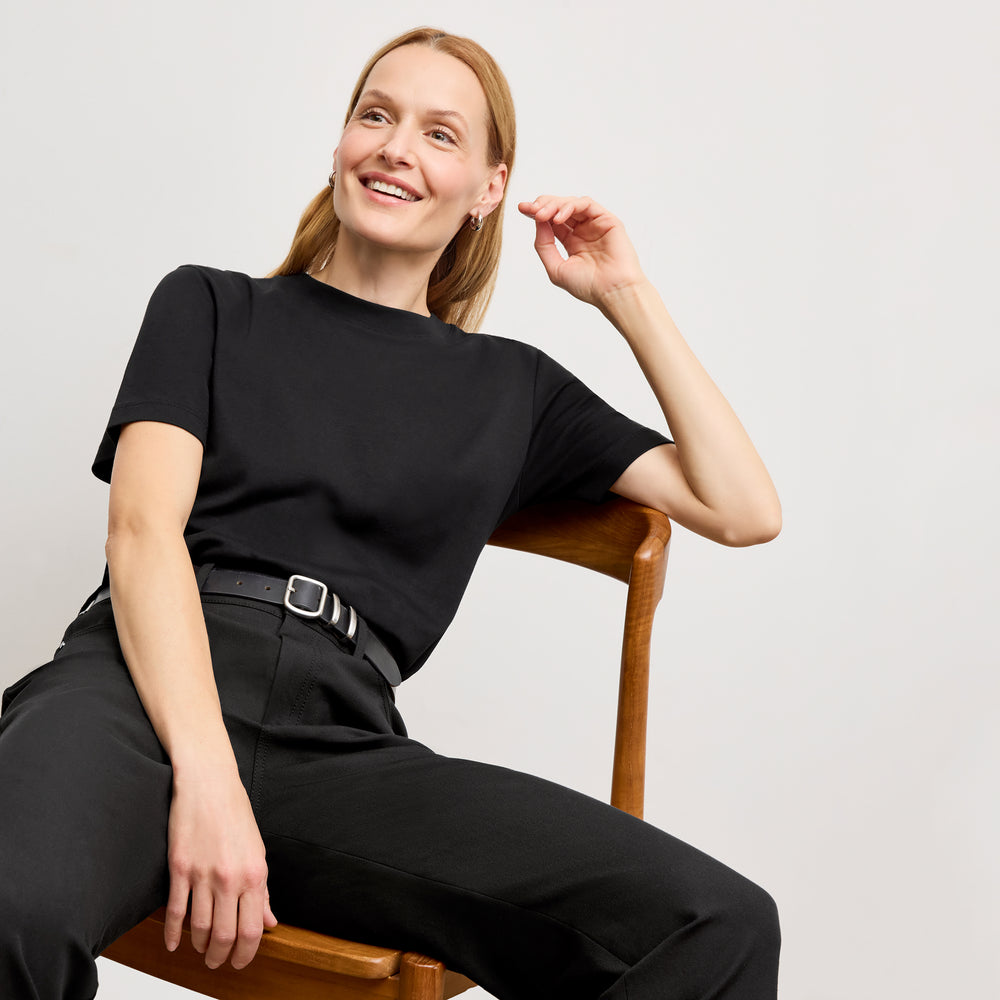 Front image of a woman standing wearing the leslie top in compact cotton in black
