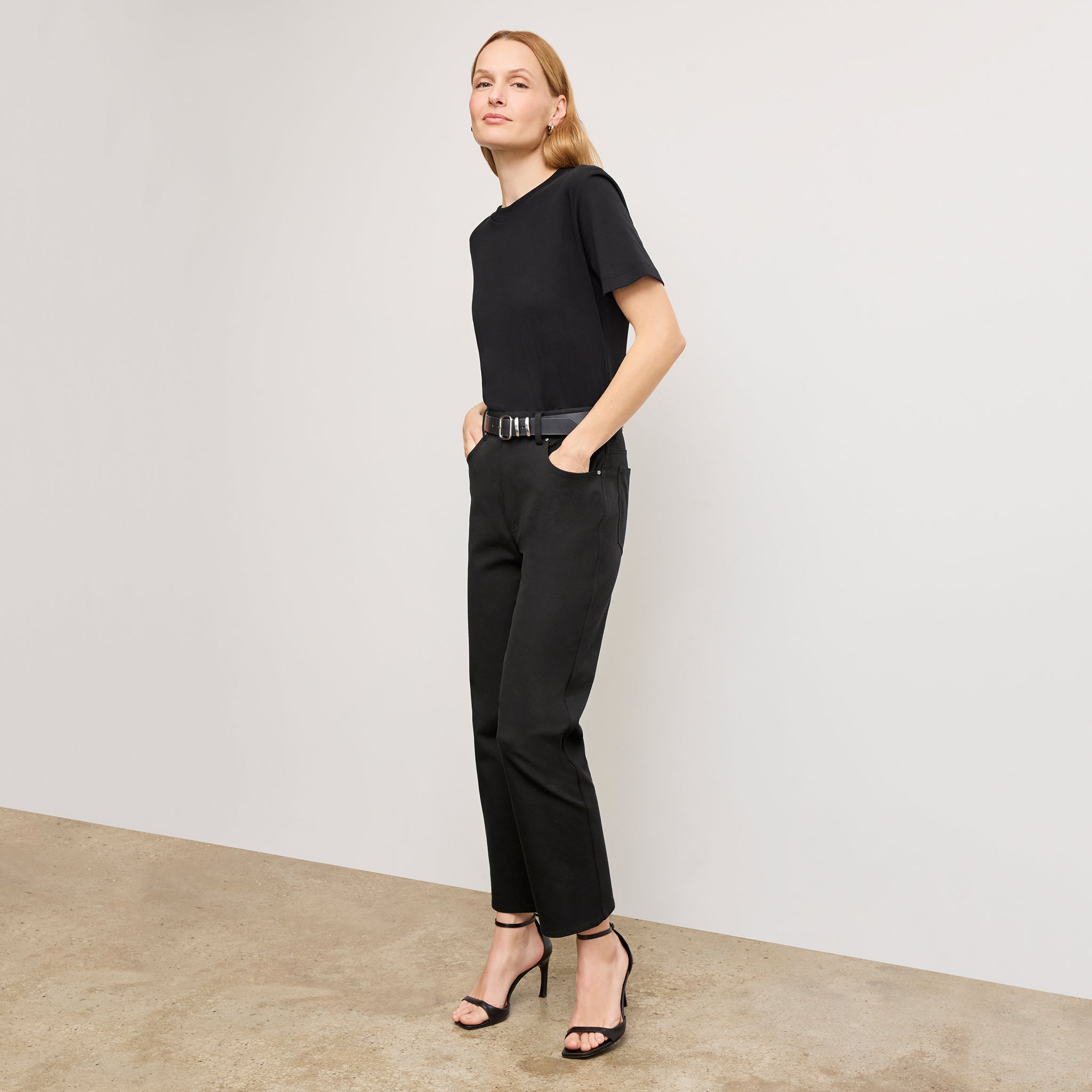 Front image of a woman standing wearing the leslie top in compact cotton in black