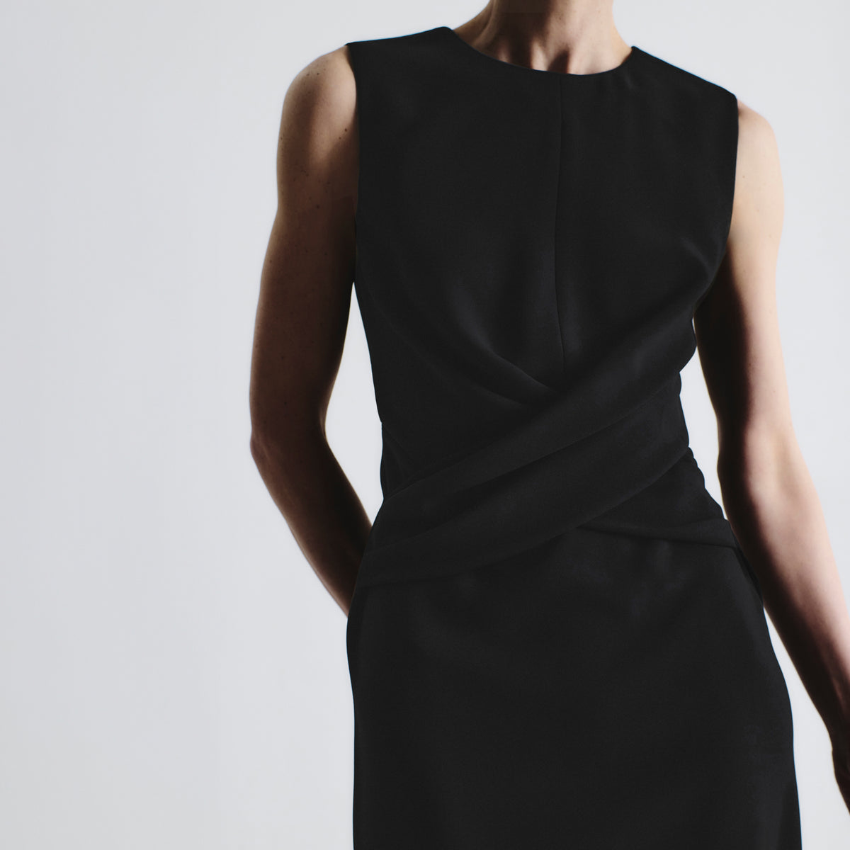 Black sleeveless dress on a plain background