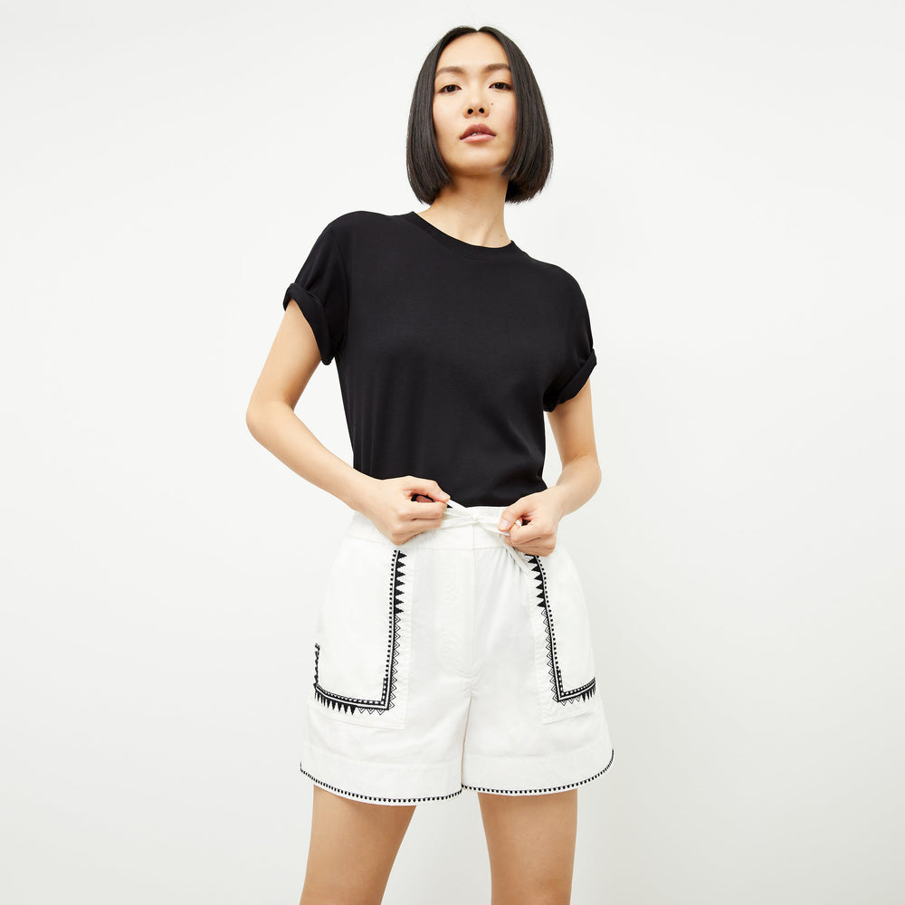 Front image of a woman standing wearing the leslie top in compact cotton in black