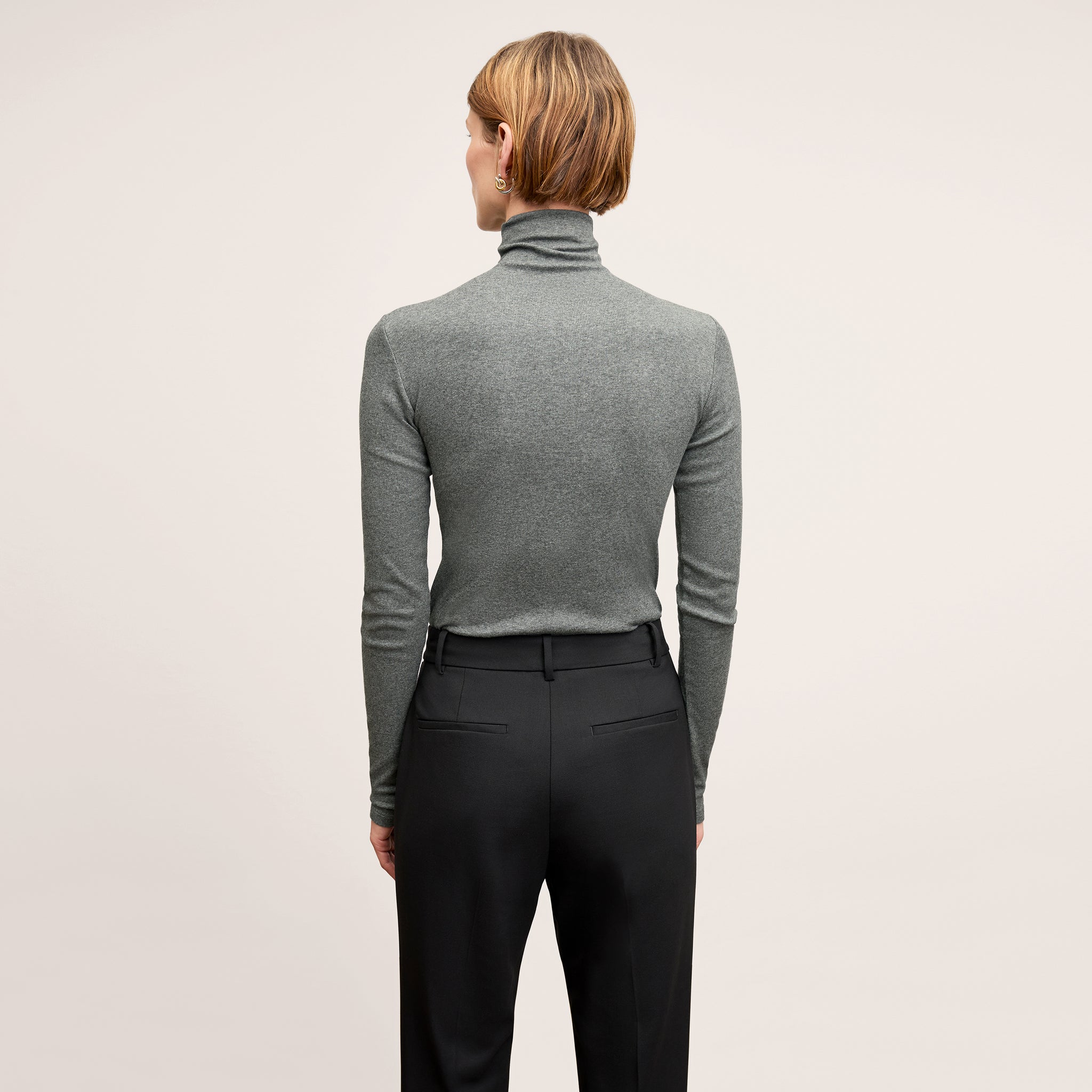 Back image of a woman wearing the Axam Turtleneck in Charcoal