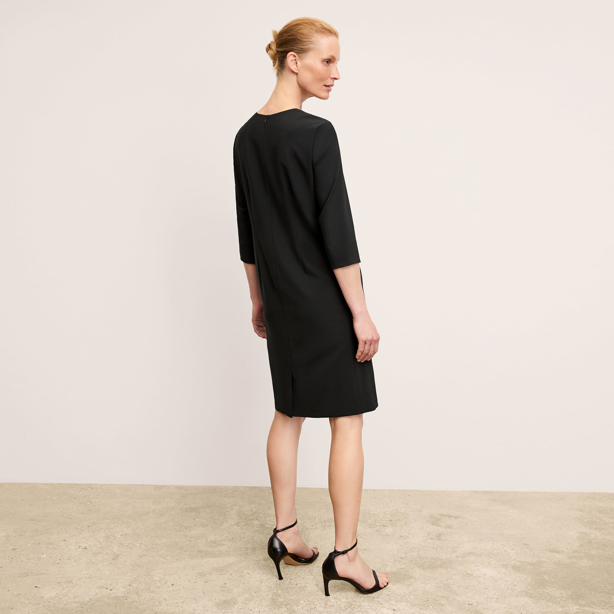 back image of a woman wearing the lancia dress in black